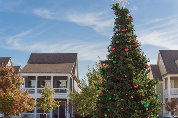 Christmas tree with snowflake tree topper and colorful glass ornaments balls at daytime