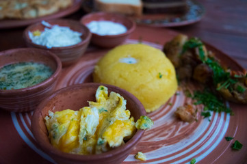 Chatterbox egg, with mamalyga, sour cream, feta cheese and meat at a traditional festival.