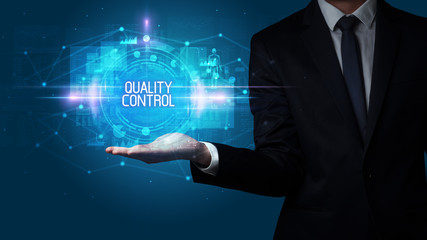 Man hand holding QUALITY CONTROL inscription, technology concept