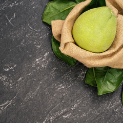 Fresh peeled pomelo, pummelo, grapefruit, shaddock on dark background in bamboo basket. Autumn...