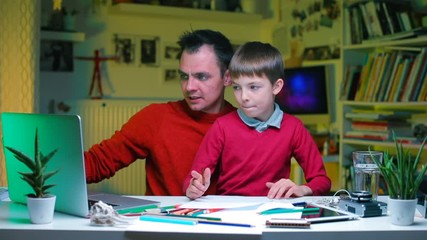  Distance school. Online School. Home education during quarantine of coronavirus infection COVID-19. A father explains financial knowledge to his son at a table in the office. - Powered by Adobe