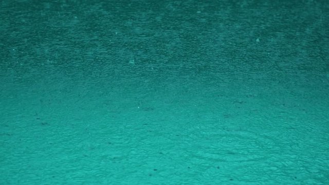 pool surface under heavy rain. surface of the sea under the falling raindrops.