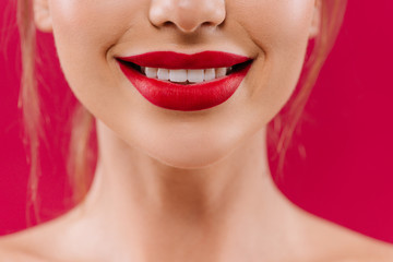 cropped view of smiling naked beautiful woman with red lips isolated on red