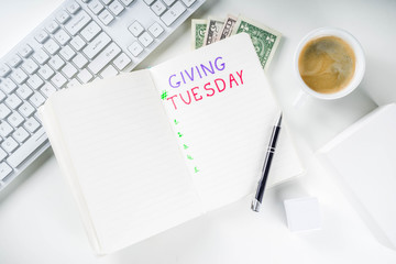 Notepad for To-Do list Giving Tuesday. White paper ready to write notes to various helping on Tuesday. International Charity Aid Day, giving hashtag activity. On a white desktop flatlay copy space