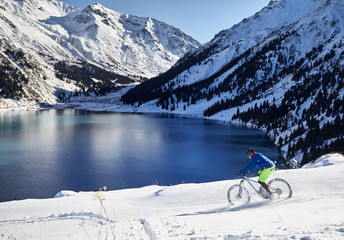 Cyclist ride in winter mountains