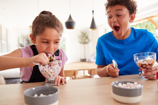 Children In Kitchen At Home Eating Ice Cream Desserts They Have Made