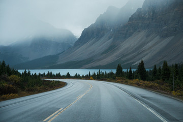 Fototapeta Scenic road trip with rocky mountain and lake in gloomy day obraz