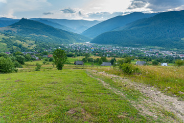 Fototapeta na wymiar Rural view on valley with small viallage and big mountains