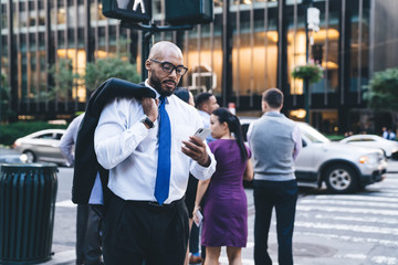Black businessman with glasses using phone