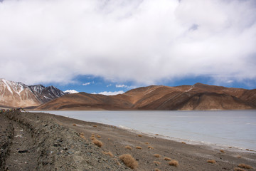 Fototapeta na wymiar View landscape with Himalayas mountains and Pangong Tso high grassland lake while winter season for indian and tibetan and foreigner travelers travel visit at Leh Ladakh in Jammu and Kashmir, India