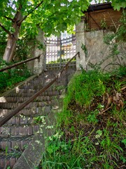 old stone staircase to the entrance wrought-iron gate of the house on the hill