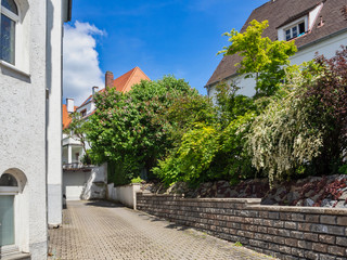 entrance to the courtyard and plants behind the stone fence of the apartment building