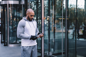 African American man using smartphone with earphones on