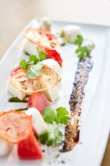 Italian traditional caprese salad. Fresh Salad with tomatoes, basil, mozzarella, and olive oil on wooden background. Mediterranean, natural and organic food concept.