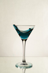 A splash of blue alcohol in a Martini glass
