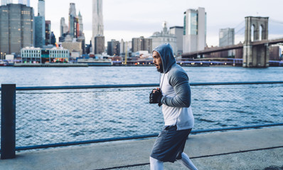 Obraz premium Concentrated male warming up in megapolis on quay