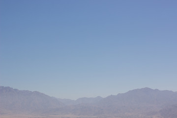 Fototapeta premium abstract wallpaper minimalism landscape of mountain ridge silhouette in morning fog blue sky simple background empty copy space for your text here 
