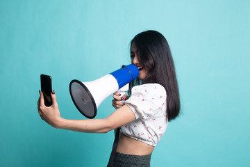 Angry young Asian woman  shout with megaphone to mobile phone