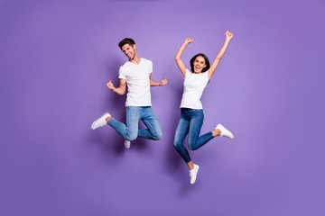 Fototapeta na wymiar Full length body size photo of cheerful excited positive ecstatic jumping people in jeans denim white t-shit footwear expressing emotions isolated pastel violet color background