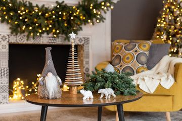 Living room decorated in Xmas style with toys placed on table. Selective focus