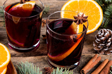 Two glasses of hot mulled wine with oranges and spices