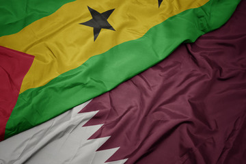 waving colorful flag of qatar and national flag of sao tome and principe .