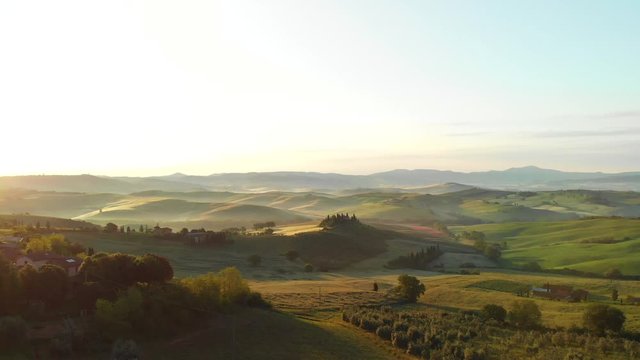 Aerial flyover the beautiful sunset landscape in Tuscany, Italy.