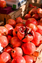 Fototapeta na wymiar Ripe pomegranates in a basket at the market. Seasonal fruits
