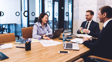 Pleased multiethnic business people having conversation during meeting in conference room