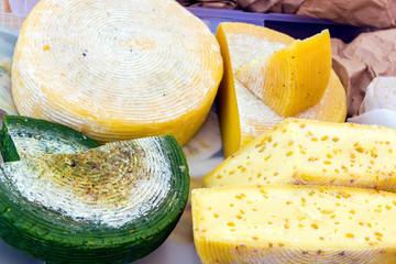 Different types of tasty cheeses on a wooden table.