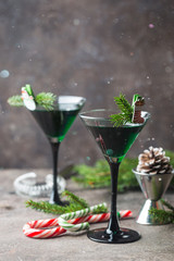 Closeup of green cocktails in martini glasses with mint leaves over gray background