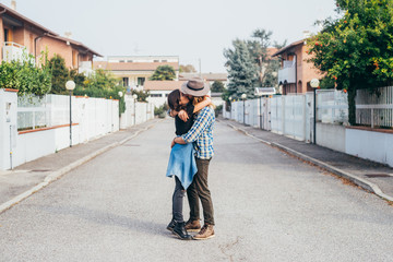 Fototapeta na wymiar Young beautiful happy couple outdoor hugging french kissing