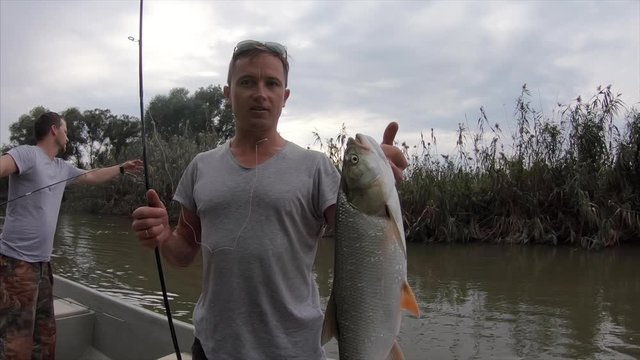 Young angler shows big asp fish in front of the camera