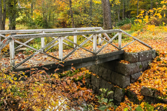 Old wooden bridge in misty autumn park in Finland