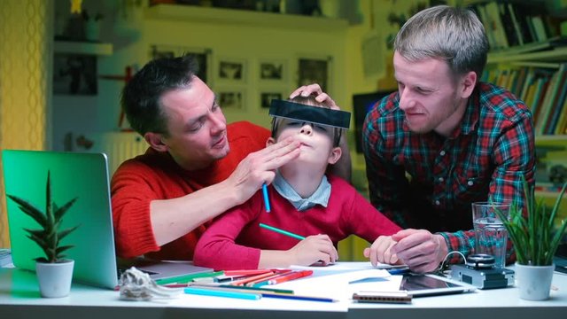 Home education, self-isolation at home COVID-19. Mental relocation of children. Same-sex couple with a child. Dad wipes his son lips.