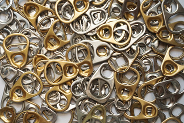 pool of silver and golden color ring tab or pull tab lid , recycle ,reuse and environment concept