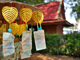 Thai style donation tree with bank note and golden bayan tree leaf waiting for pyaing merit to monk...
