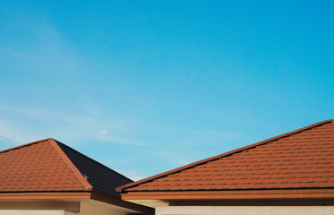 red shingle roof and blue sky on sunny day
