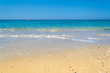 Fototapeta na wymiar Long ocean waves at sandy beach in Greece