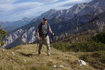 Fototapeta na wymiar NB__9828 Hiker with backpack and walking sticks on mountain path