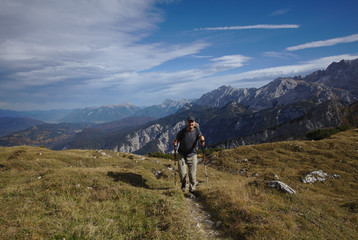Fototapeta na wymiar NB__9831 Hiker with backpack and walking sticks on mountain path