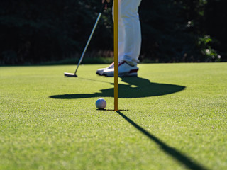 Golf course putting green with golf ball. Golf course with a rich green turf beautiful scenery.