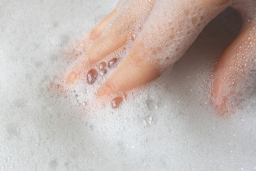 Woman hand in white pure soap foam or shampoo. Gentle hygiene