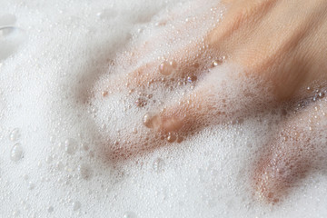 Hand in white pure soap foam or shampoo. Gentle hygiene