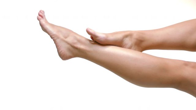 Close up on smoth woman legs with healthy skin over white background.
