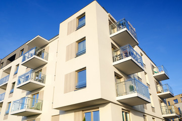 Exterior of a modern  white apartment building with balcony. No people.