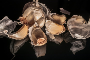 Fresh organic garlic with reflection on shiny black background