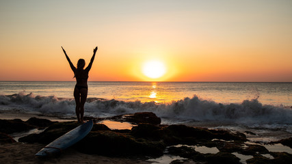 silhouette of woman on the beach at sunset