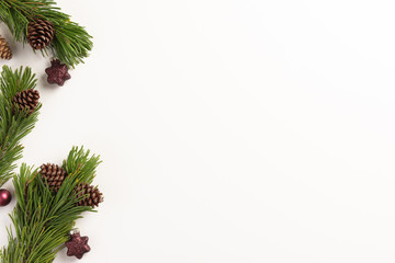 Fototapeta premium Christmas composition. Spruce branches with cones and christmas decorations, on a white background. Christmas, winter, new year concept. Flat lay, top view, copy space.