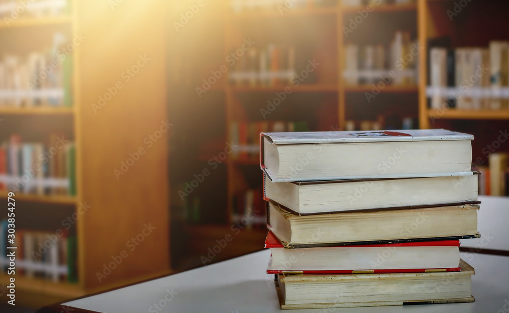 Aufkleber stack of books in the library and blur background